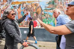 An Oakland mural depicting Native-American genocide was defaced. It led to a debate on the street.